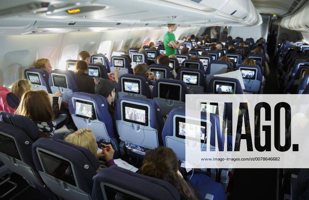 Passagiere schauen das Unterhaltungsprogramm im Economy Class Bereich in einem Flugzeug. Berlin, 23.02.2016, , available, , Berlin Deutschland