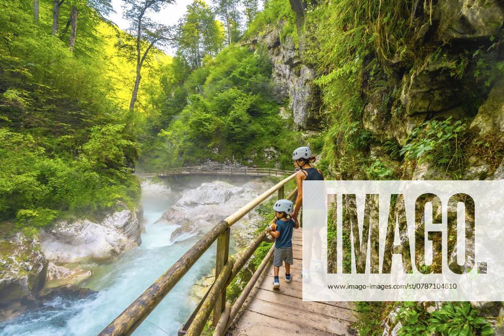 Mutter und Kind wandern auf einem Holzpfad in der Vintgar Schlucht in der Nähe von Bled und genießen den Sommerurlaub in der wunderschönen Natur Sloweniens Mother and child walking on wooden path exploring vintgar gorge near bled, enjoying summer vacation in beautiful nature of slovenia
