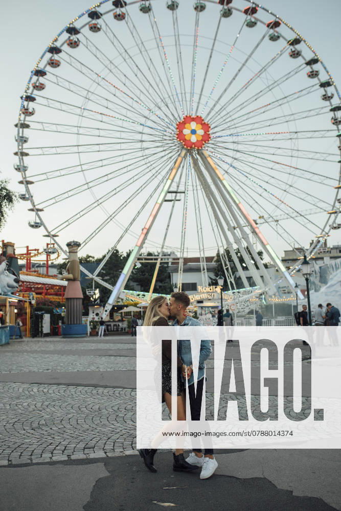 Young couple in love, kissing and embracing at a funfair model released, Symbolfoto, LHPF00096