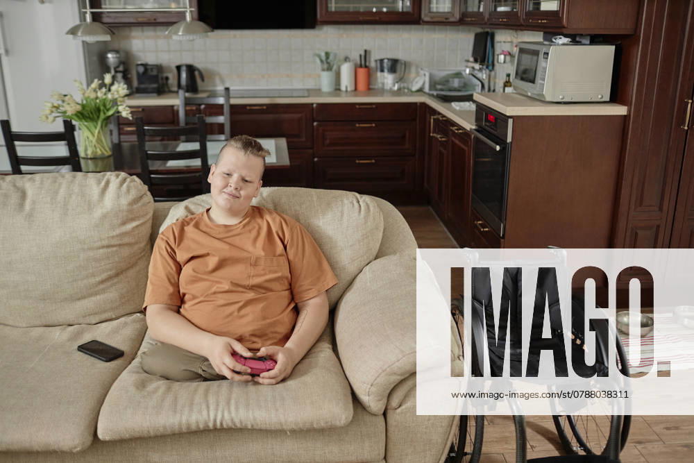 IMAGO Creative, Lifestyle, Gaming Boy with disability playing video game at home model released, Symbolfoto property released, KPEF00861