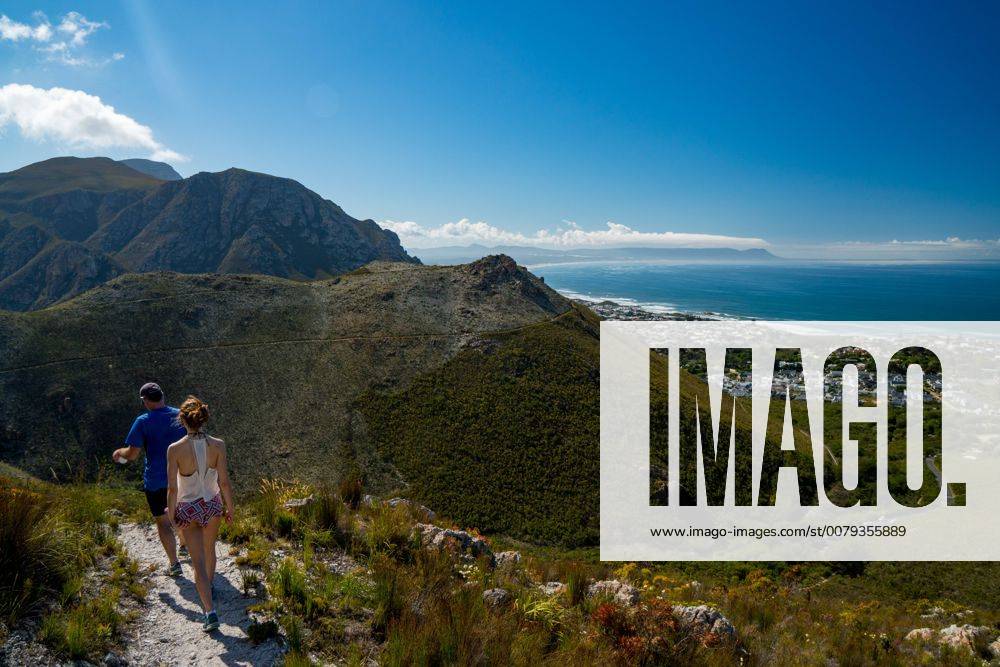Man and woman hikers walking down into Hermanus from the mountain, Hermanus, South Africa, Africa