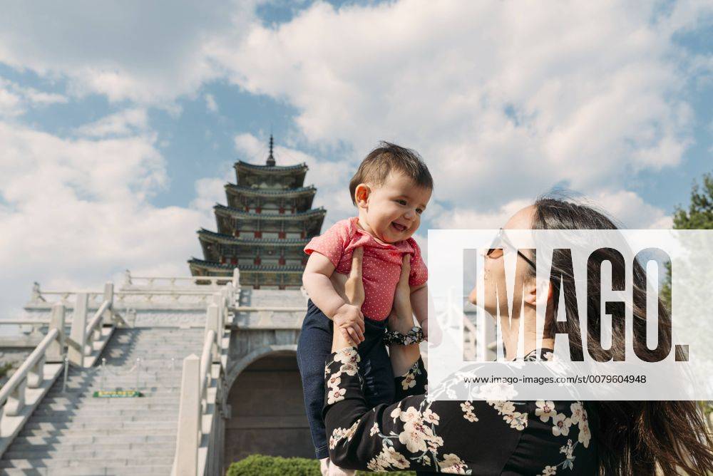 South Korea, Seoul, happy woman holding a baby girl in front of the National Folk Museum of Korea, inside Gyeongbokgung Palace model released Symbolfoto GEMF01693