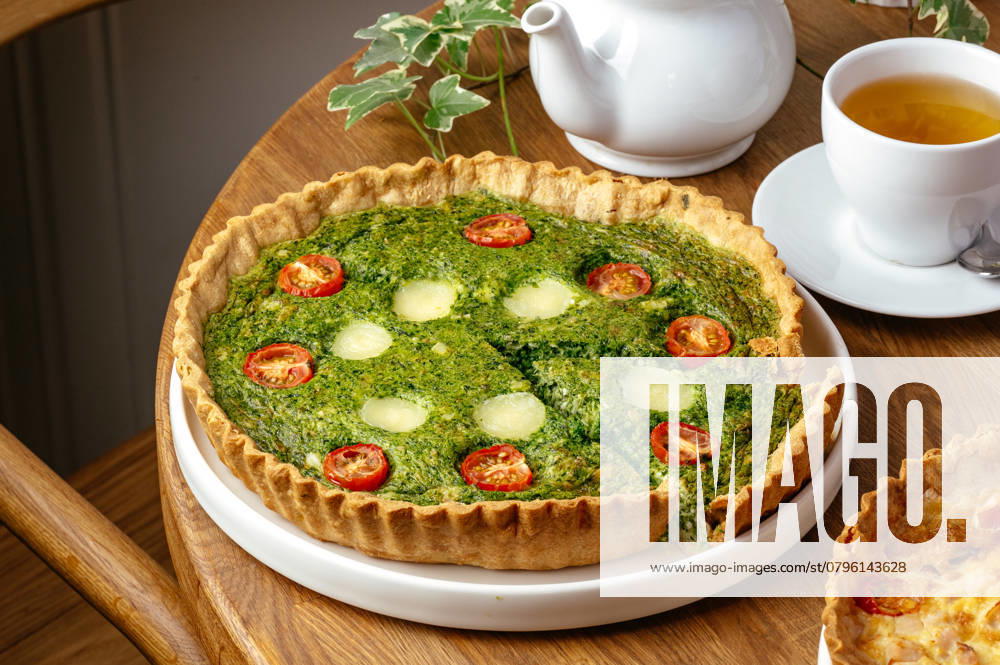 Quiche with tomatoes and spinach on a plate R_KUAL250119-1540516-01