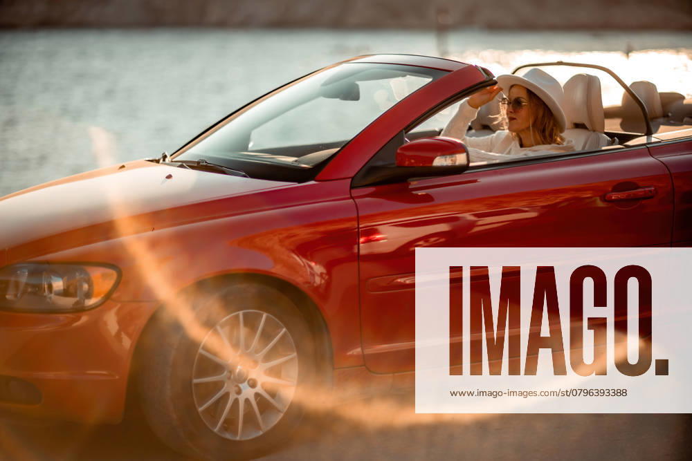 Outdoor summer portrait of stylish blonde woman driving red car convertible. Fashionable attractive woman with blond hair in a white hat in a red car. Sunny bright colors taken outdoors against the sea, model released, , 48402456.jpg, red, car, convertible, vehicle, female, stylish, hat, blonde, fair, portrait, hair, attractive, outdoors, woman, adult, pose, posing, pretty, sunglasses, model, drive, fashion, automobile, person, style, long, people, auto, street, nice, trip, sea, elegance, traveler, beautiful, glamour, background, rocks, cute, driver, women, lady, tourism RECORD DATE NOT STATED