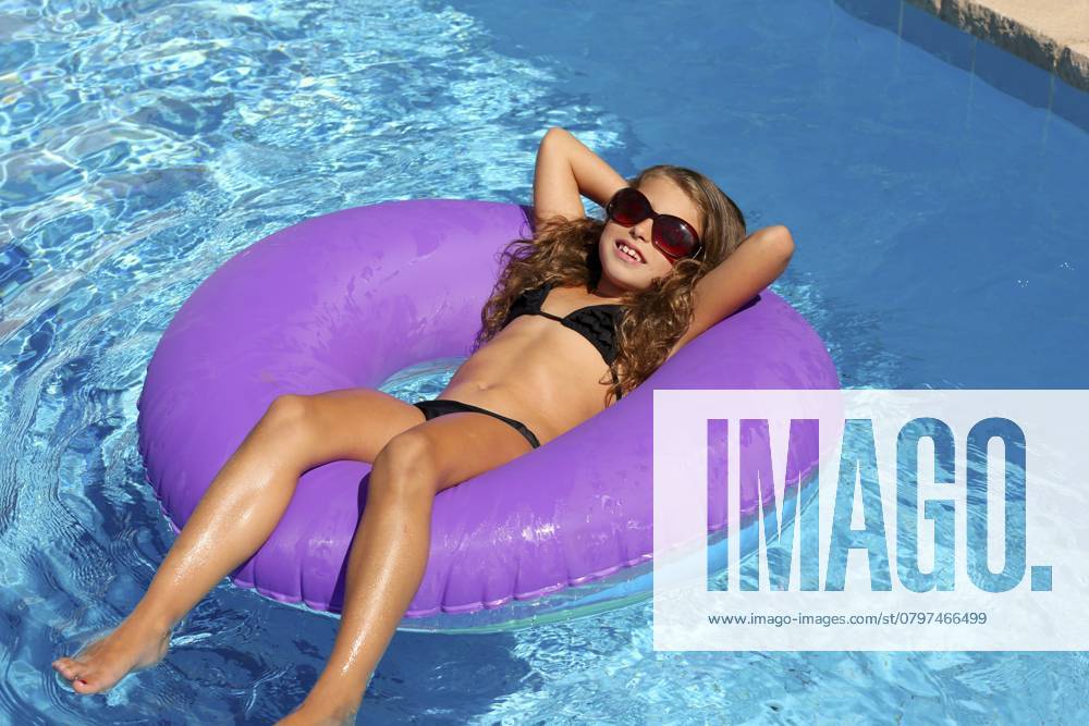 Bikini Kinder Mädchen mit Sonnenbrille entspannt auf lila aufblasbaren Pool Ring Bikini children girl with sunglasses relaxed on purple inflatable pool ring