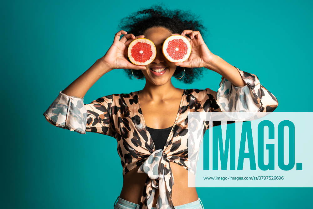 Pretty african american woman in leopard print top with two half of juicy grapefruit on blue studio background. Healthy eating, dieting, antioxidants concept. High quality photo, model released, , 48807800.jpg, adult, african american, attractive, background, beautiful, beauty, bright, care, caucasian, cheerful, citrus, closeup, color, colour, comical, copy space, coral, cute, delicious, detox, diet, eat, eating, expressing, eyes, female, food, fresh, fruit, girl, grapefruit, half, hand, happy, healthy, holding, humorous, isolated, lifestyle, person, ripe, space, summer, vacation, vacation concept, vivid lifestyle, white, woman, young RECORD DATE NOT STATED