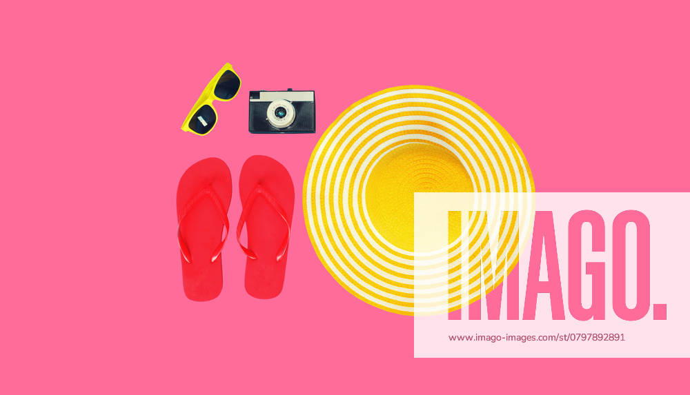 Sommerferien-Accessoire, gelber Strohhut mit Flip Flops, Filmkamera und Sonnenbrille Summer vacation, yellow straw beach hat with flip flops, film camera and sunglasses on colorful pink background, top view