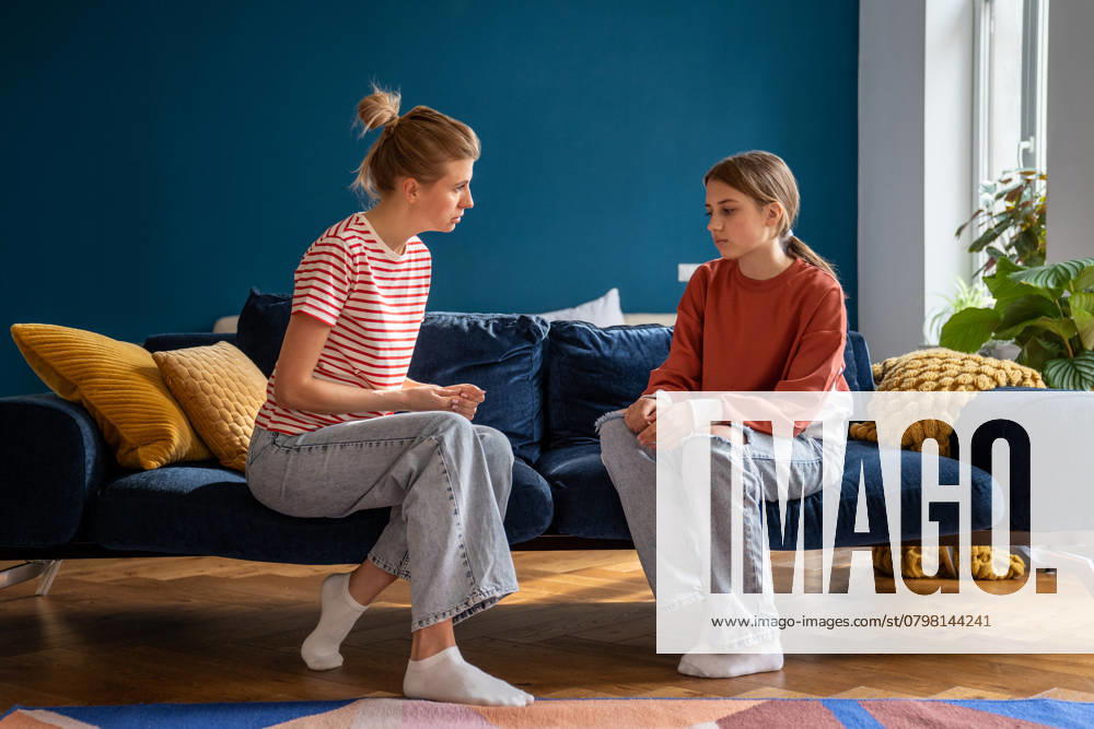 Schwieriges Gespräch zwischen Mutter und traurigem Teenager zu Hause. Aufgeregtes Teenager-Mädchen hört auf die Ermahnungen der Mutter Difficult conversation between single mother and teenager at home. Important conflict adolescent topic between woman and daughter. Family misunderstanding. Upset teen girl listens to mom admonitions ,model released, Symbolfoto