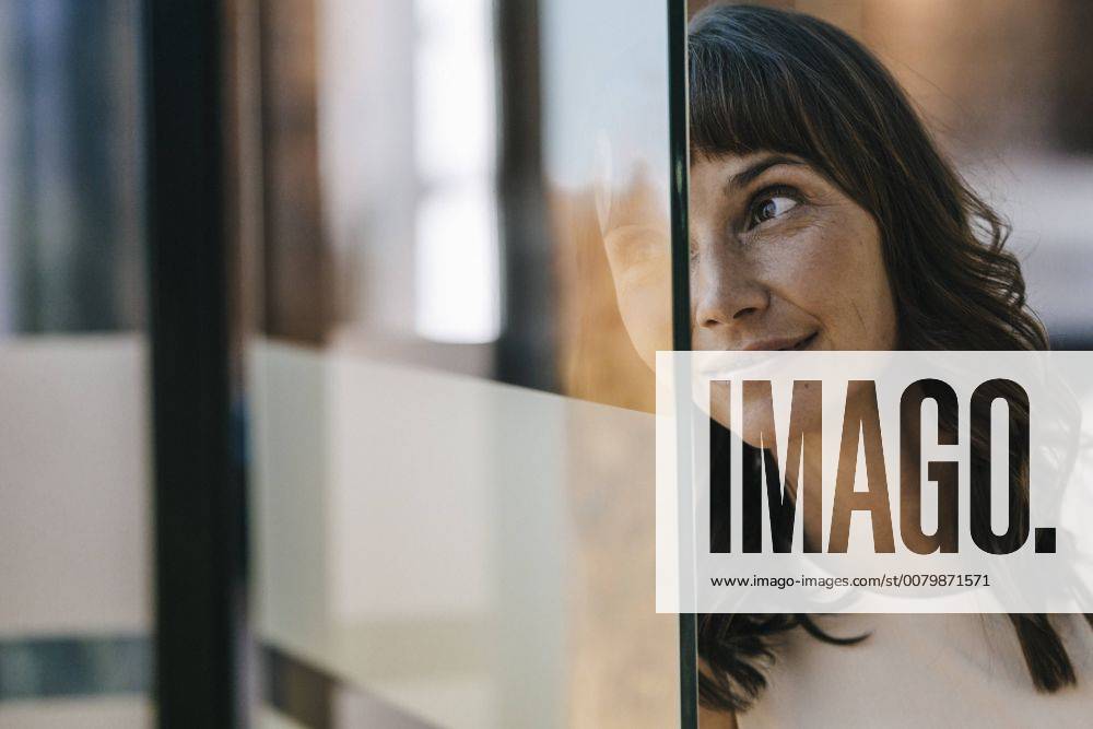 IMAGO Creative: Corporate: Klimaschutz, Digitalisierung und Urbanisierung Portrait of a businesswoman looking through glass pane model released Symbolfoto property released KNSF01988