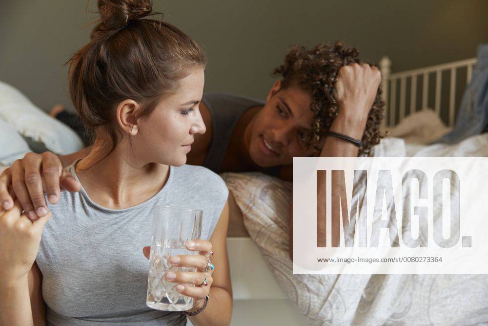 Young couple sitting on bed, talking model released Symbolfoto property released SUF00270