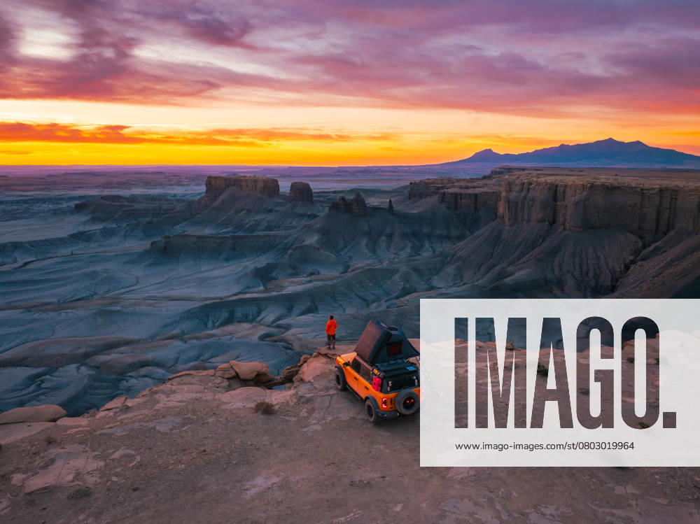 Yellow Truck Rooftop Tent Camping on a Cliff with a Lone Traveler Hanksville, Utah, United States CR_EVVA250214-1639823-01 ,model released, Symbolfoto