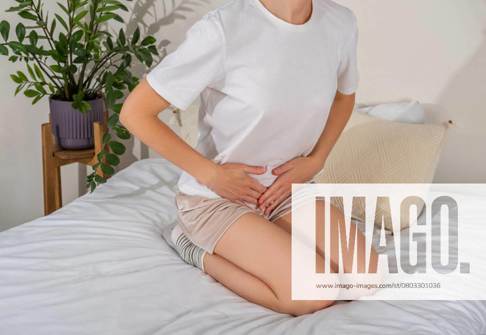 Gynäkologische Probleme oder Menstruationsbeschwerden. Frau, die den Schritt hält, Symptom Bauchschmerzen, Schmerzen im Genitalbereich. Frau mit Unwohlsein während der Menstruation Gynecological problems or menstrual disorder. Woman holding crotch, stomachache symptom, genital pain. Woman experiencing discomfort during menstruation ,model released, Symbolfoto