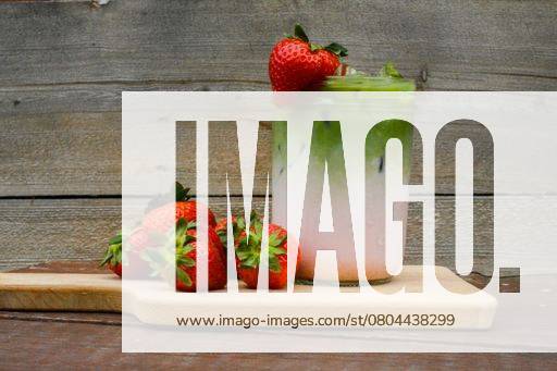 A refreshing strawberry matcha latte in a glass jar with fresh strawberries on a wooden board against a rustic wooden background. 28553227 RECORD DATE NOT STATED