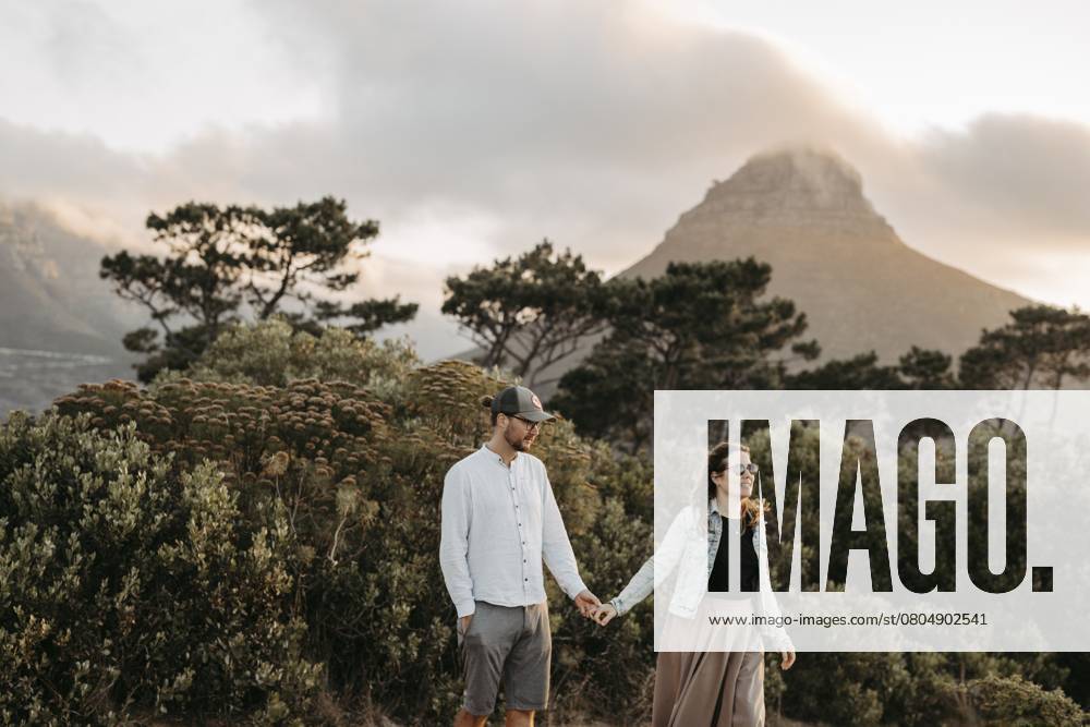 Paar steht bei Sonnenuntergang vor dem Signal Hill, Kapstadt, Südafrika Couple standing in front of Signal Hill at sunset, Cape Town, South Africa, Africa
