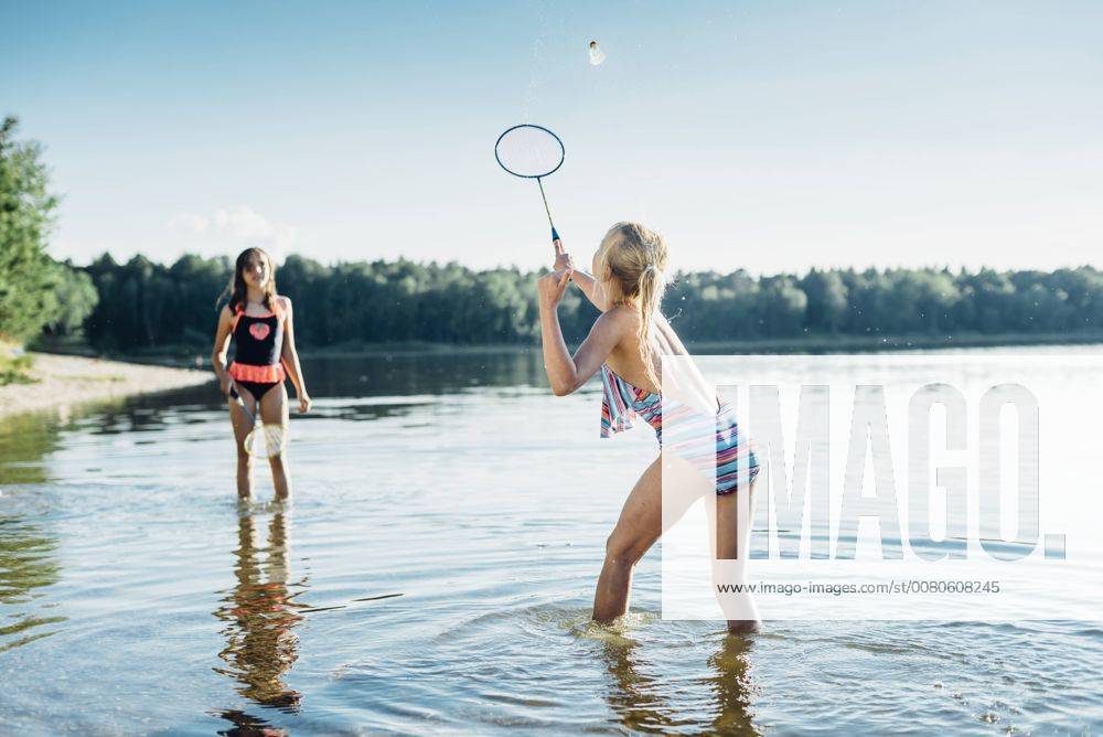 Two friends playing shuttlecock at lakeshore model released Symbolfoto MJF02186