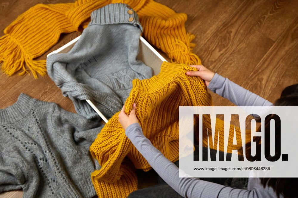 Die Hände einer Frau mit einem gestrickten Wollpullover. The hands of a woman with a knitted wool sweater. The concept of restoring order, cleaning, cluttering, organizing space. ,model released, Symbolfoto