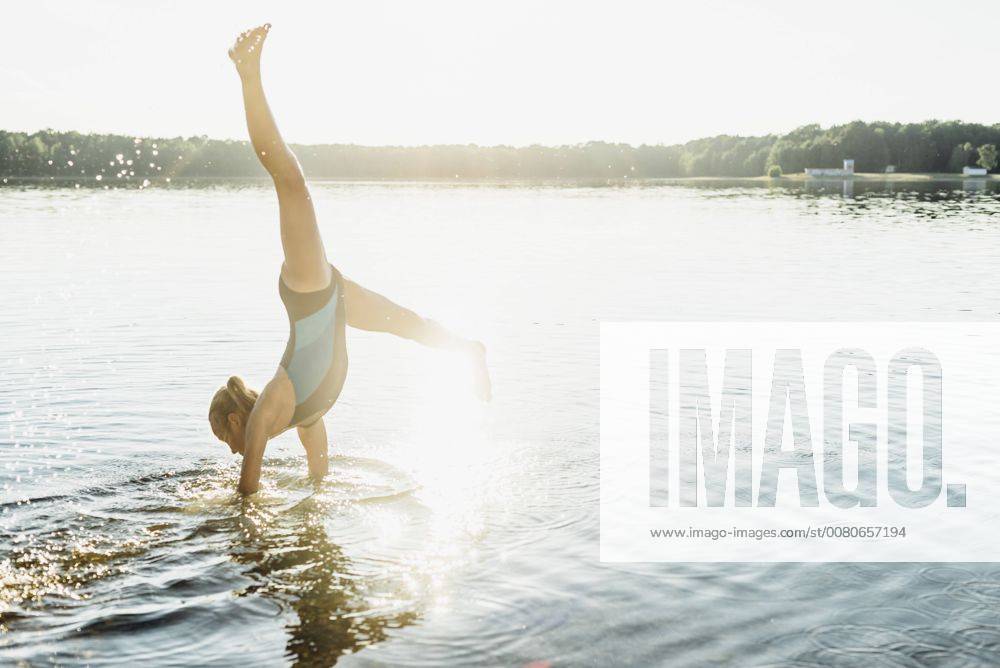 Girl doing cartwheel at lakeshore model released Symbolfoto MJF02202