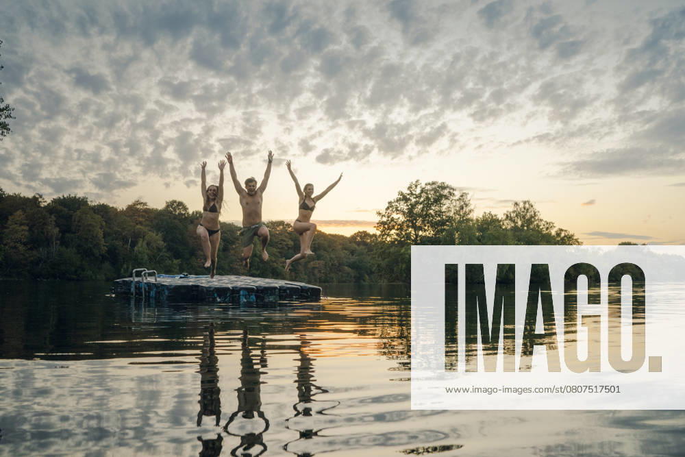 Friends having fun at the lake, jumping from bathing platform model released, Symbolfoto property released, GUSF02326