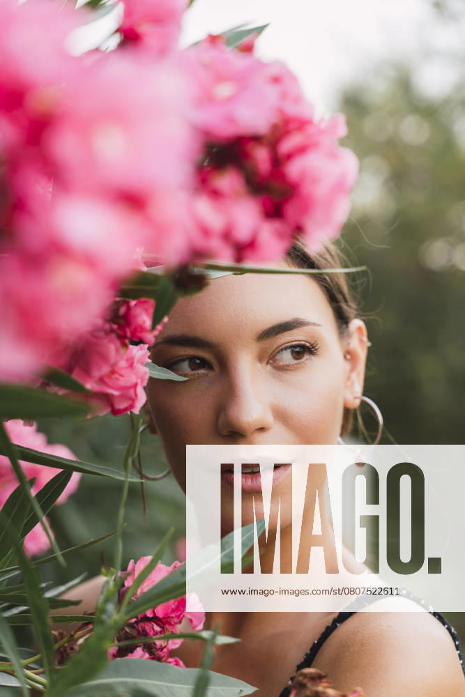 Portrait of young woman in a park with pink blossoming flowers model released, Symbolfoto, AFVF04205