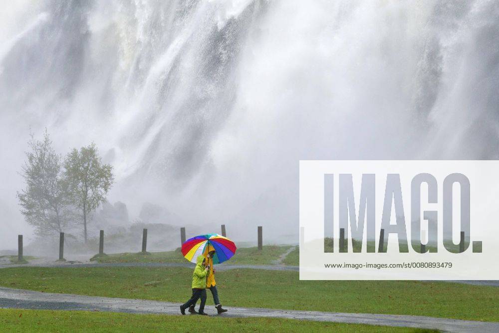 Spaziergänger mit buntem Regenschirm vor Wasserfall, Powerscourt Wasserfall, Enniskerry, County Wicklow, Irland, Europa