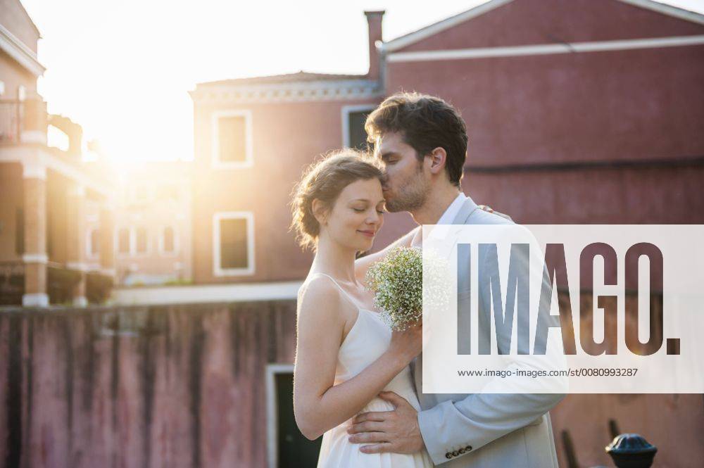 Italy, Venice, groom kissing bride at sunrise model released Symbolfoto DIGF02856