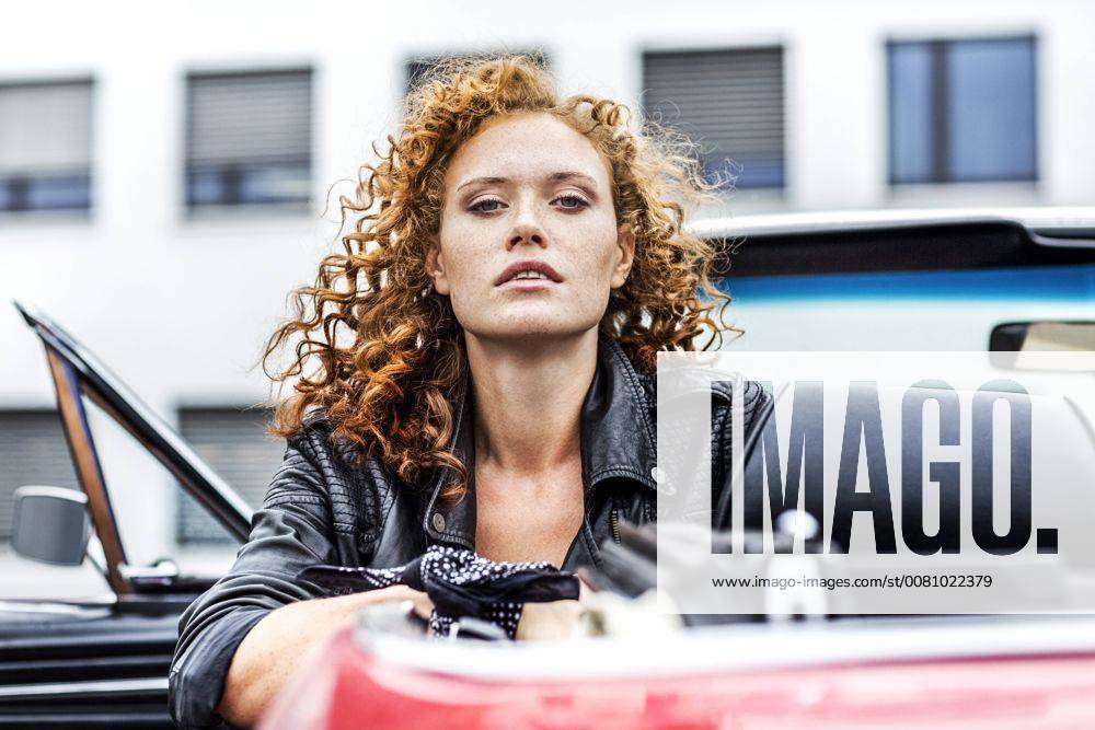Portrait of confident redheaded woman in sports car model released Symbolfoto FMKF04518