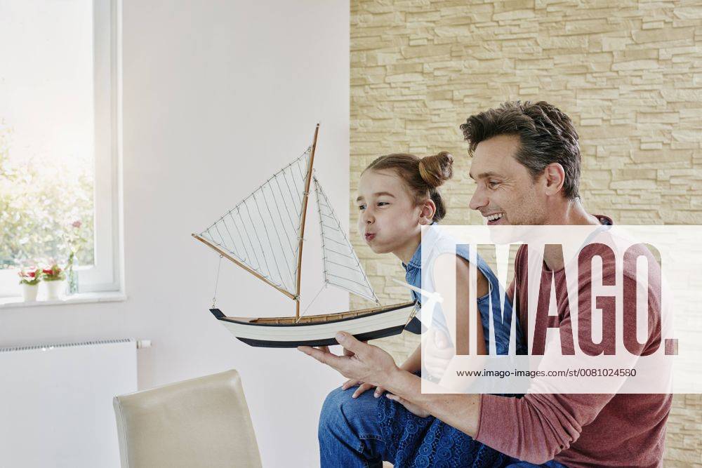 Happy father and daughter playing with model boat at home model released Symbolfoto property released RORF01034