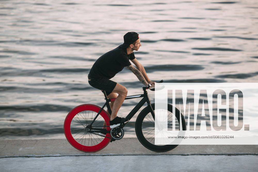 Young man riding fixie bike at the waterfront model released Symbolfoto VPIF00195