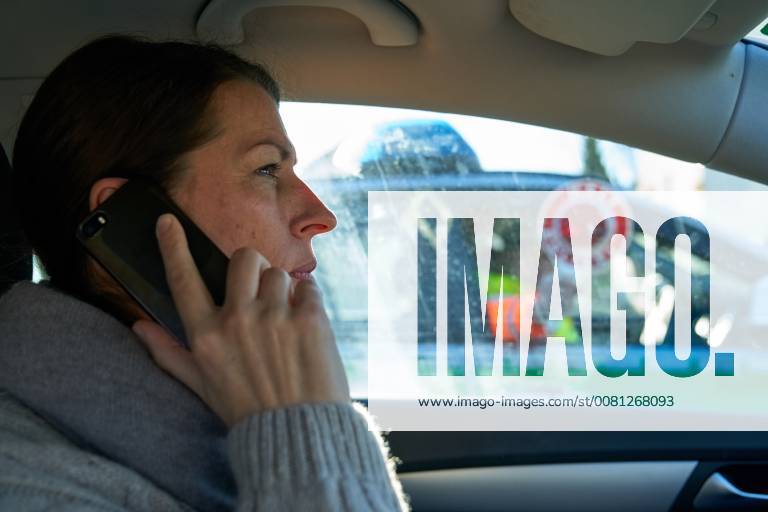 Junge Frau mit Handy am Steuer eines PKW (gestellte Szene) bei einer Polizeikontrolle in Marktoberdorf, Bayern, Deutschland am 07.12.2017 FRAU AM STEUER MODEL RELEASED
