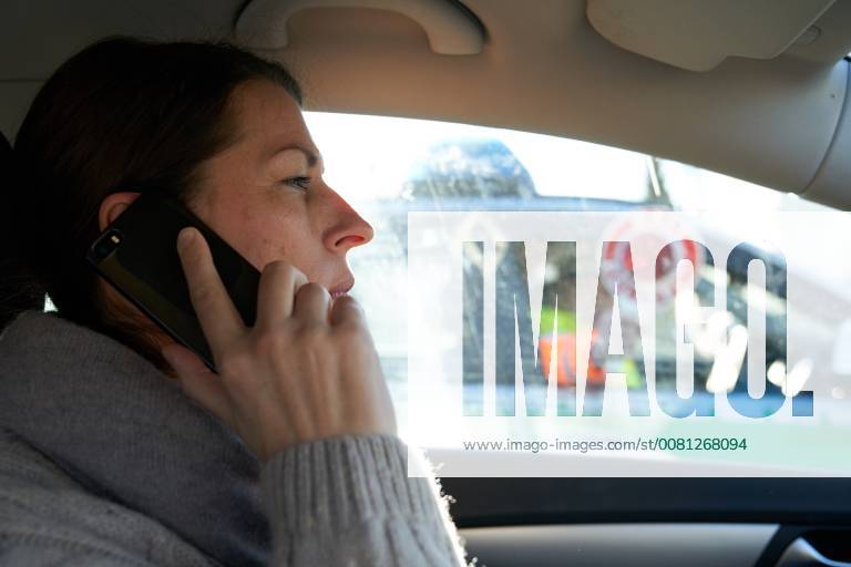 Junge Frau mit Handy am Steuer eines PKW (gestellte Szene) bei einer Polizeikontrolle in Marktoberdorf, Bayern, Deutschland am 07.12.2017 FRAU AM STEUER MODEL RELEASED