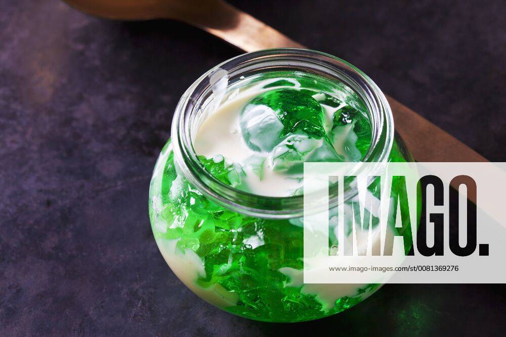 Green woodruff jelly in a glass with vanilla sauce CSF28395