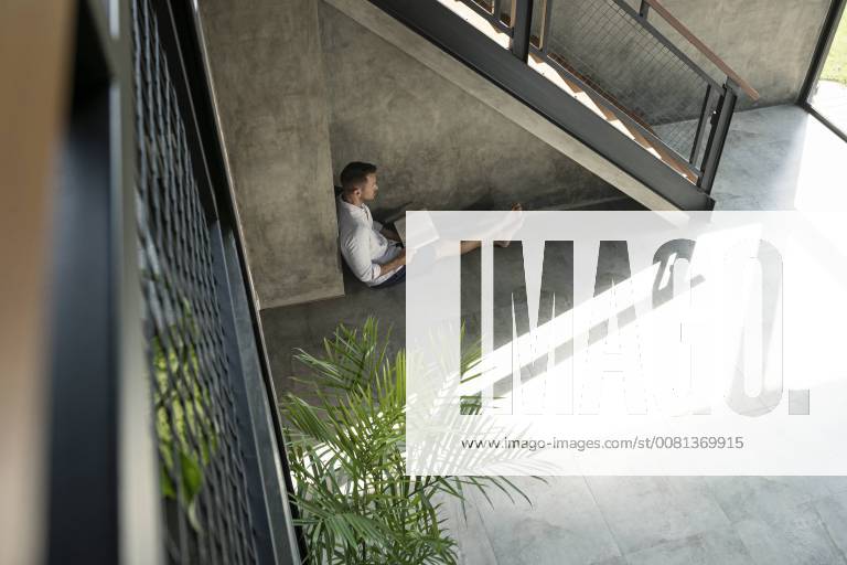 IMAGO Creative, Jahreszeit Sommer, Hitze IMAGO Creative, Sommer, Schatten-Plätze bei Hitze Mature man sitting under staircase, reading a book model released Symbolfoto property released SBOF00873