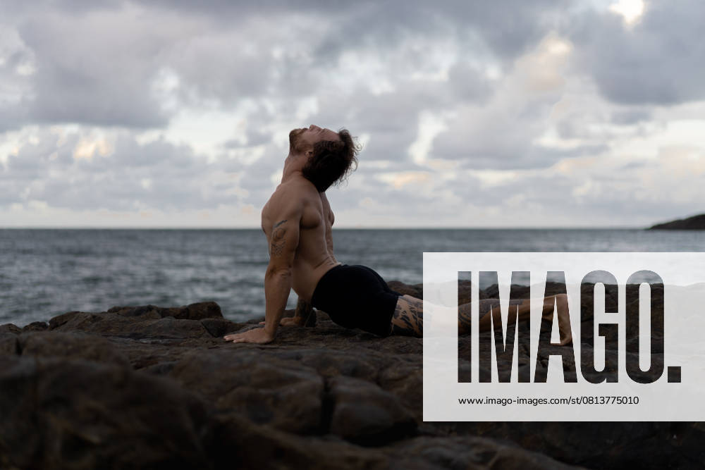 Man practices yoga at a rocky beach by the ocean Sunshine Coast, Queensland, Australia CR_YUKI250421-1709042-01 ,model released, Symbolfoto