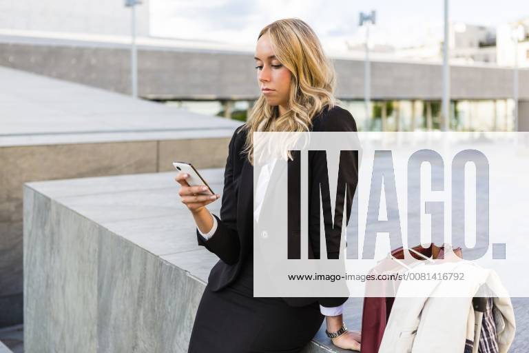 Businesswoman looking at cell phone model released Symbolfoto MGIF00187