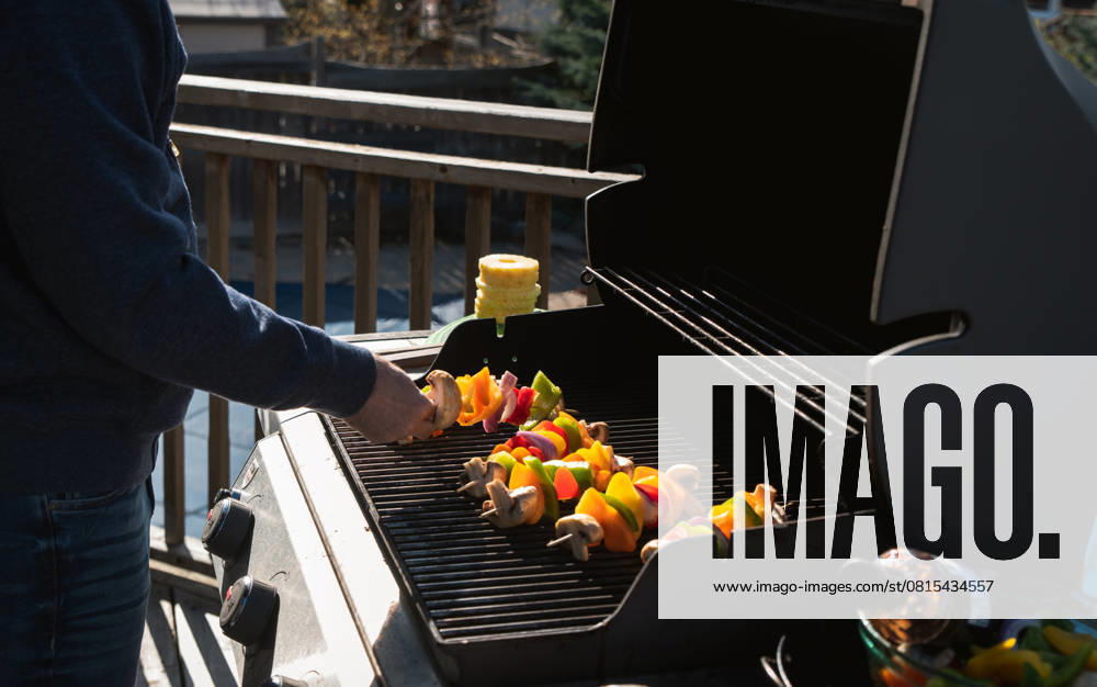 Man putting vegetable skewers on a gas bbq grill outdoors. Kingston, ON, Canada R_DOHO210506L-735069-01 ,model released, Symbolfoto