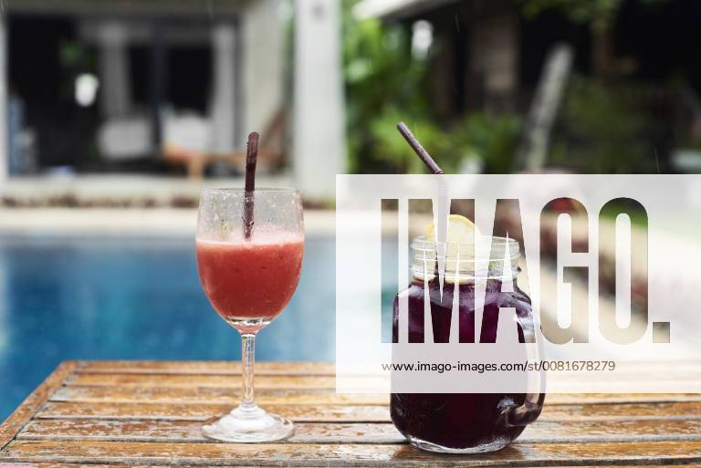 Two fruity cocktails at the poolside in rain property released IGGF00238