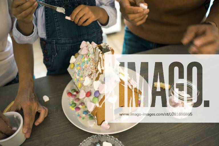 Family pasting gingerbread house in kitchen for Christmas with sweets model released Symbolfoto property released MOEF00379