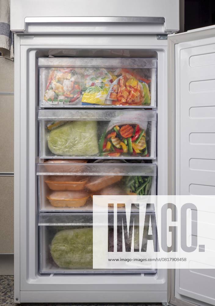 Geöffneter Tiefkühlschrank mit gefrorenem Gemüse und Fleisch. Gefrorene Lebensmittelvorräte Krise, Lebensmittelvorrat für Quarantäne Isolation Zeitraum Opened freezer refrigerator with frozen vegetables and meat. Freezed food supplies crisis, food stock for quarantine isolation period