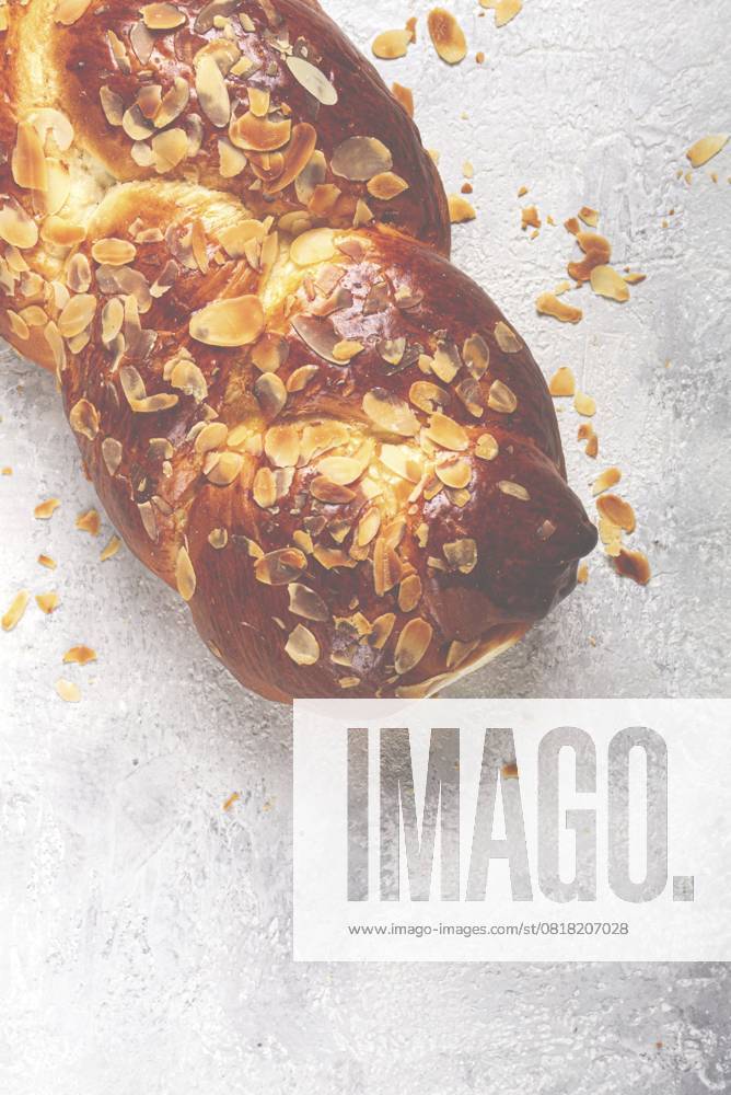 Geflochtener, süßer Brotkuchen, mit gehobelten Mandeln, Frühstück, geflochtenes Brot, Brioche, auf einem hellen Hintergrund, Draufsicht, keine Personen Braided, sweet bread pie, with sliced almonds, breakfast, braided bread, brioche, on a light background, top view, no people