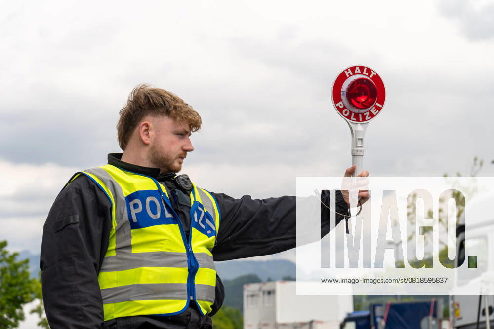 Grenzkontrolle der Bundespolizei an der Kontrollstelle Kiefersfelden, Inntal Ost, an der Autobahn A93 zwischen Deutschland und Österreich. Ein Polizist hält auf der Autobahn eine Polizeikelle mit Aufschrift HALT POLIZEI