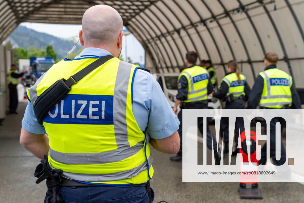 Grenzkontrolle der Bundespolizei an der Kontrollstelle Kiefersfelden, Inntal Ost, an der Autobahn A93 zwischen Deutschland und Österreich. Polizist steht vor einer Grenzkontrollstation zur sicherung der Kollegen