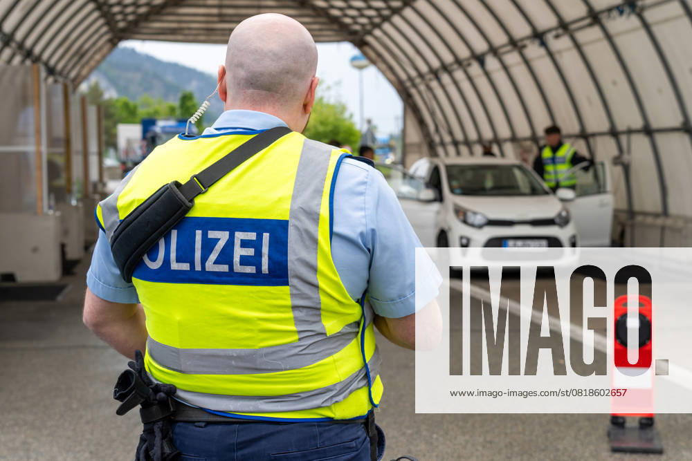 Grenzkontrolle der Bundespolizei an der Kontrollstelle Kiefersfelden, Inntal Ost, an der Autobahn A93 zwischen Deutschland und Österreich. Polizist steht vor einer Grenzkontrollstation zur sicherung der Kollegen