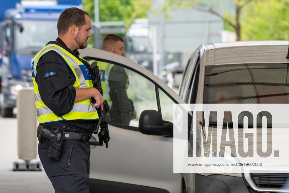 Grenzkontrolle der Bundespolizei an der Kontrollstelle Kiefersfelden, Inntal Ost, an der Autobahn A93 zwischen Deutschland und Österreich. Polizeibeamter mit Maschinengewehr steht vor einer laufenden Kontrolle an der Grenzkontrollstelle