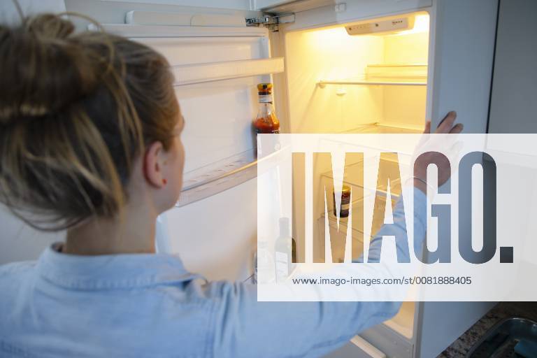 Gestellte Aufnahme: Eine Frau schaut in einen leeren Kuehlschrank. Berlin, 13.02.2018. Berlin Deutschland