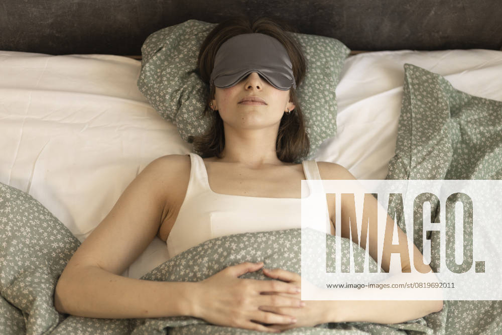 Woman sleeping in bed wearing a silk sleep mask, top view R_DCGM250515-1732432-01 ,model released, Symbolfoto