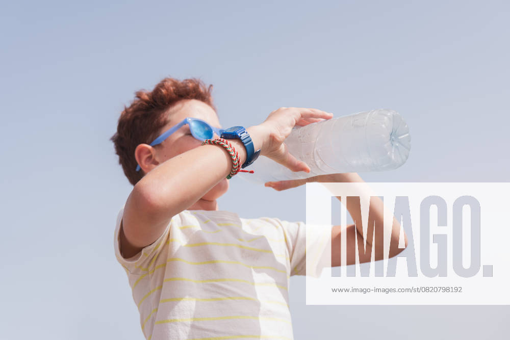 IMAGO Creative, Jahreszeit Sommer, Hitze MR_ID28744_21106_MariasunMuNoz.jpg MR_ID28744_21107_EtxahunUnzueta.jpg MR_ID28744_21108_ArhaneUnzueta.jpg A young child wearing sunglasses drinks water from a clear bottle on a sunny summer day. The sky is clear blue, emphasizing the warm and bright seasonal atmosphere Model Released HodeiUnzueta_ID28744_849077_028