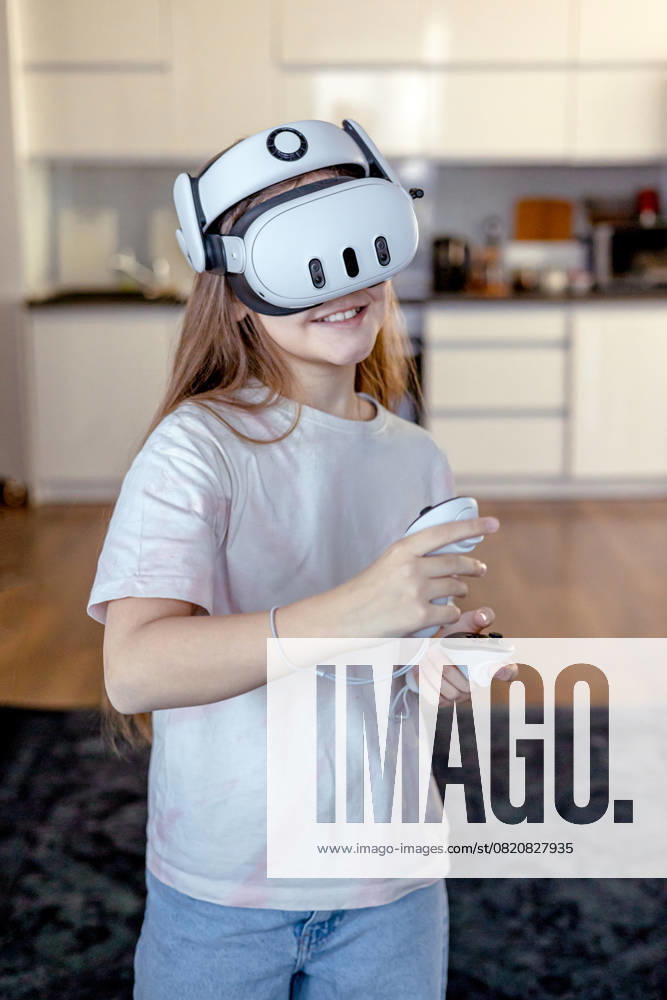 IMAGO Creative, Lifestyle, Gaming Girl in VR glasses playing a game at home. Learning and playing with augmented reality glasses. Technology and development Model Released VolhaShestak_ID27584_792132_004