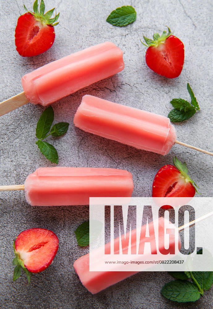 Homemade frozen strawberry ice cream popsicles and fresh strawberries on a concrete background. Summer dessert Model Released OlenaRudo_ID29237_934388_026