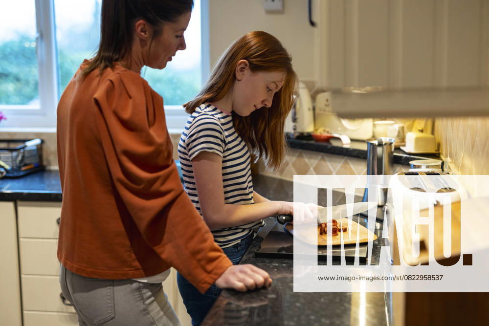 Mother supervising daughter chopping food in the kitchen model released, Symbolfoto property released, WPEF09745
