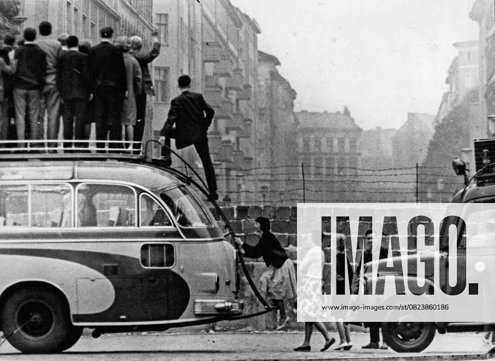 Auto Autoteile Motoren Reifen Transport Fahrzeuge 9. September 1961 - Sightseeing-Busse für Westdeutsche: Es heißt, es sei ein böser Wind, der nichts Gutes bringt. Die westdeutschen Busunternehmen in Berlin haben einen Weg gefunden, die geteilte Stadt zu ihrem Vorteil zu nutzen, indem sie Bustouren entlang der von den Kommunisten errichteten Mauer anbieten. An Aussichtspunkten halten die Busse, und die Passagiere können auf das Dach klettern, um Schnappschüsse über der Mauer zu machen. Das Foto zeigt Passagiere, die während der Sightseeing-Tour auf das Busdach klettern.